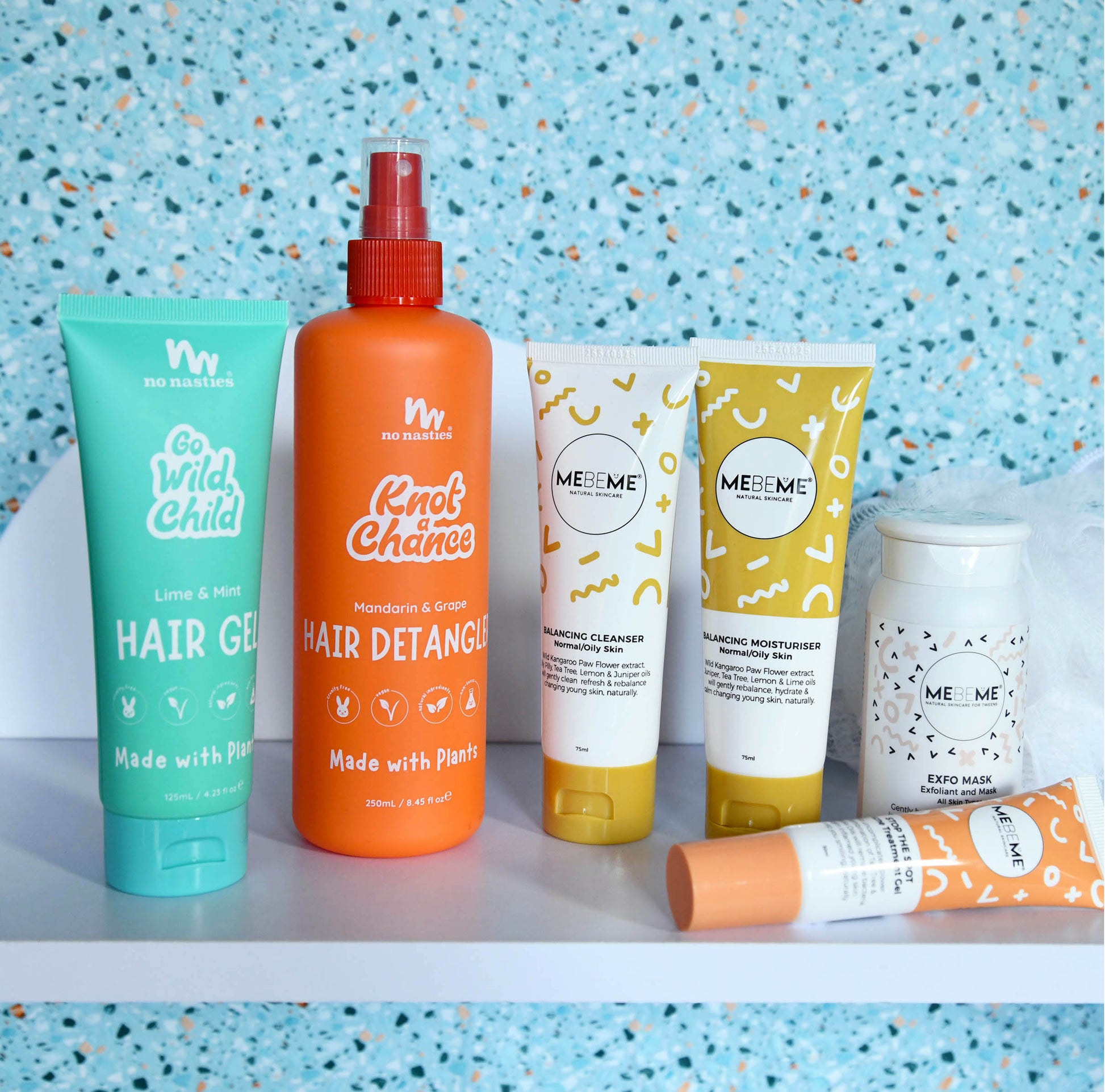 Collection of hair care products on a shelf with a blue speckled background