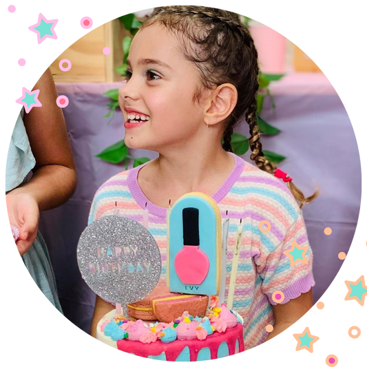 little girl smiling in front of birthday cake