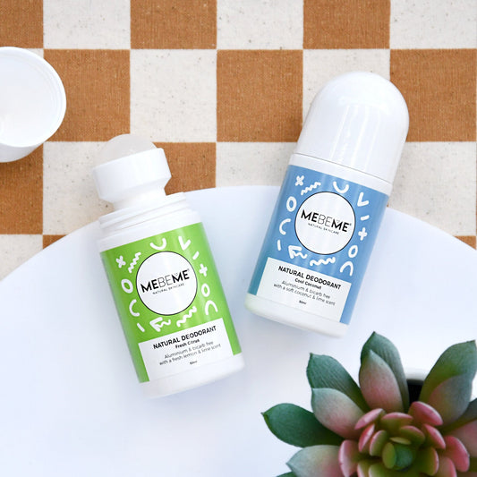 two mebeme branded eodorants on a plate on a rust and cream checkered tablecloth with a succulent in the bottom right corner