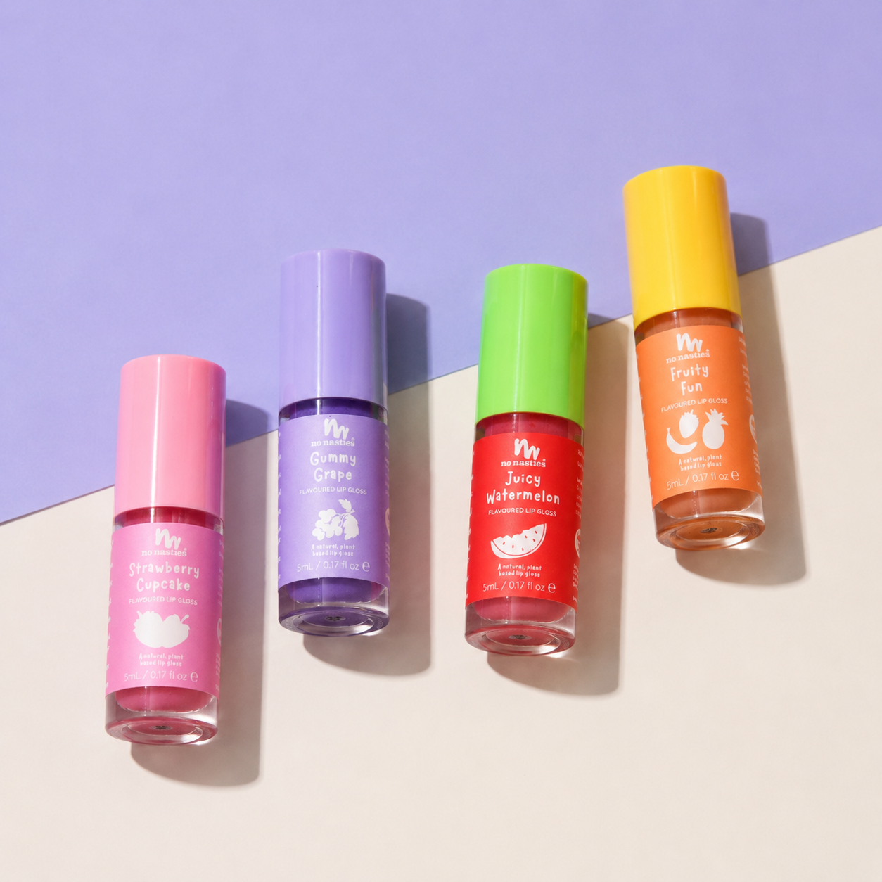 Four bottles of fruit-flavored nail polish arranged diagonally on a split beige and lavender background. The bottles are labeled Strawberry Cupcake (pink), Gummy Orange (purple), Juicy Watermelon (red), and Fruits Fun (orange), each with a cap color matching its polish shade.