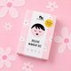 A pink and white box for the 'no nasties Deluxe Makeup Set' featuring a cute cartoon girl illustration and a yellow 'formulated for kids in 2023' badge, set against a pink background decorated with paper flowers.
