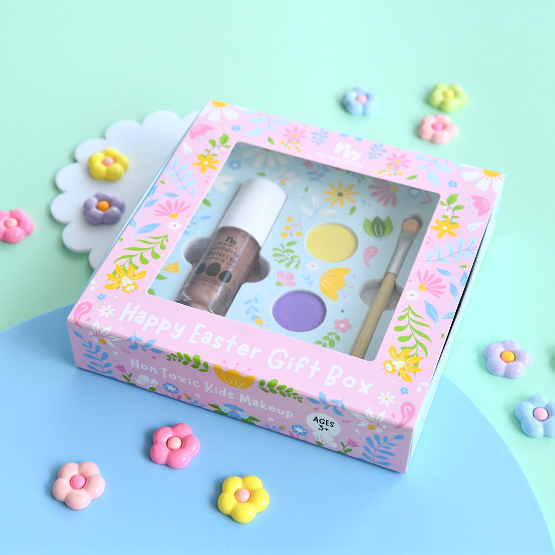 Children's makeup set in a decorative box with floral designs on a colorful background.