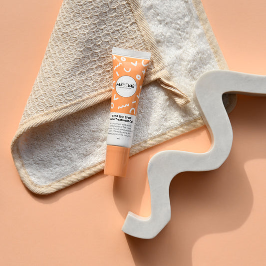 Tube of 'ME ME' skincare product on a textured surface with a decorative letter 'S'.