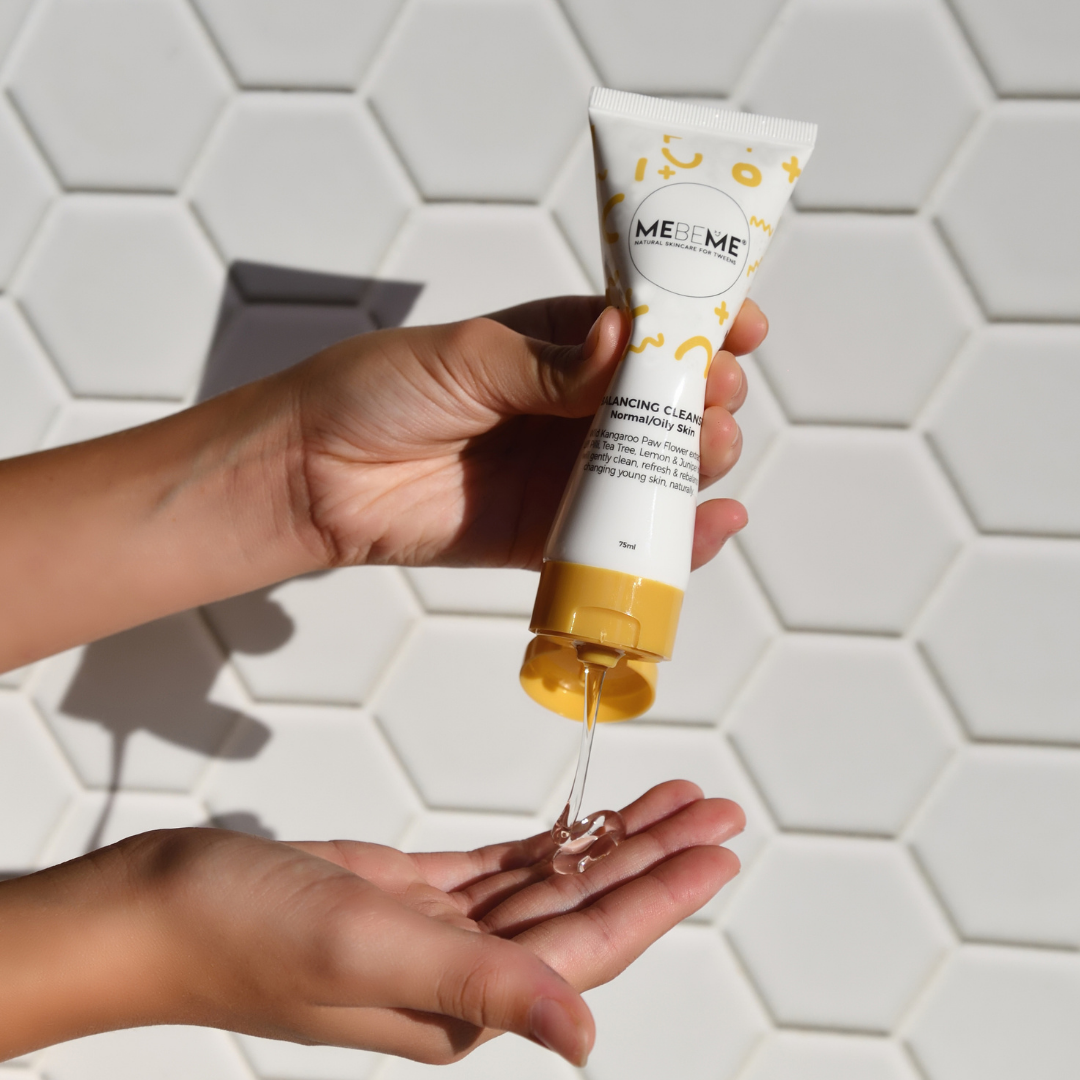 Hand holding a tube of ME ME skincare product with a hexagonal tile background