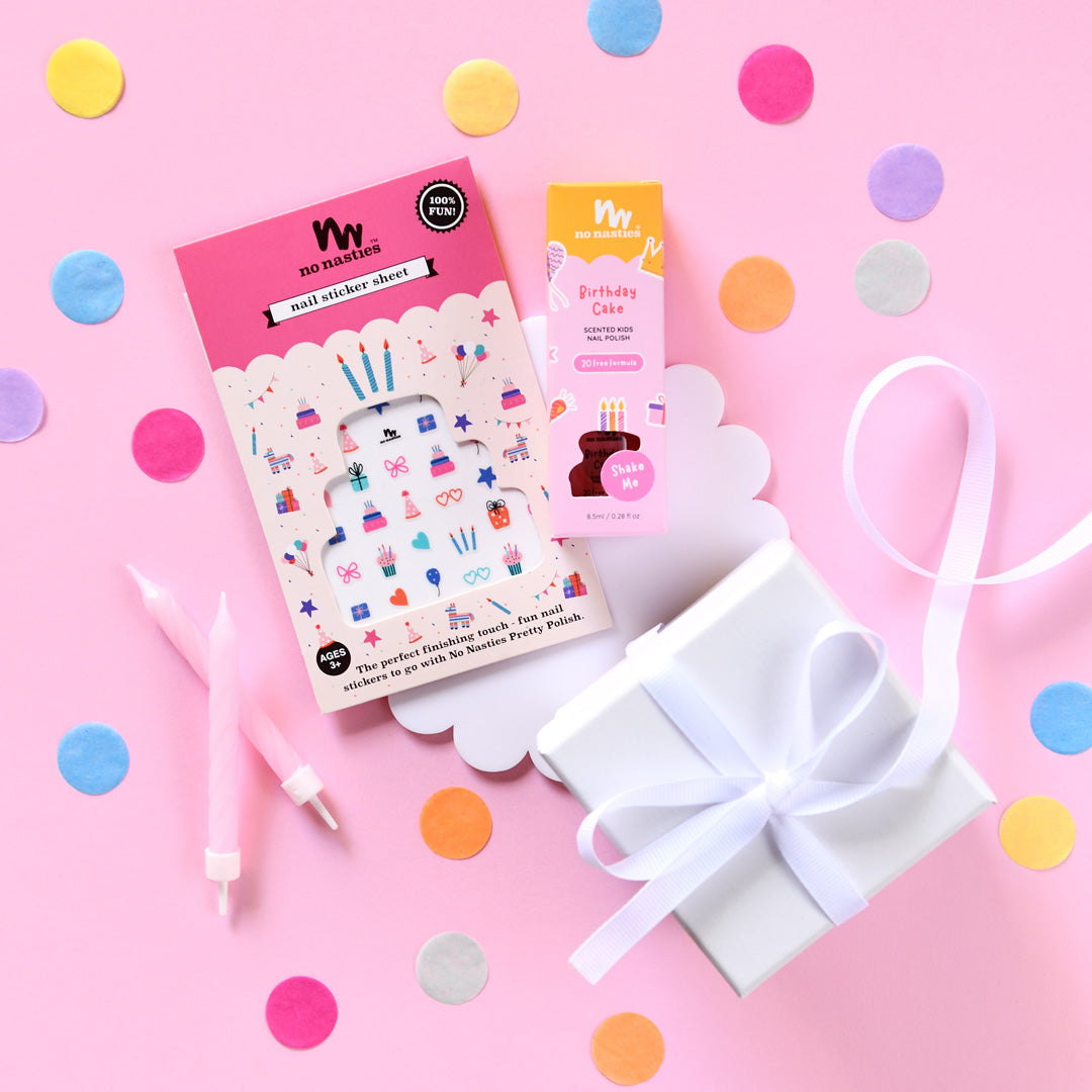 Nail art supplies including stickers and a gift box on a pink background with colorful confetti.