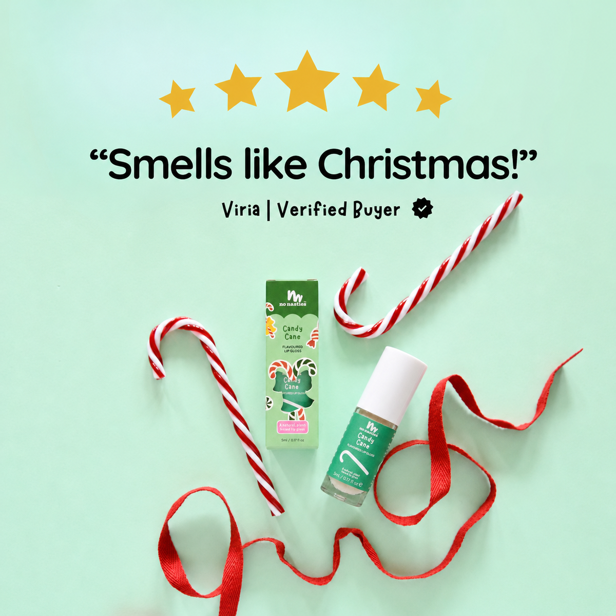 A holiday-themed product listing graphic featuring a green and white 'My Scent' Candles by the Sea 'Pinaud' scented candle box and matching bottle, styled with red-and-white striped candy canes and red ribbon on a mint green background. Text above reads 'Smells like Christmas!' with a 'Viria | Verified Buyer' badge.