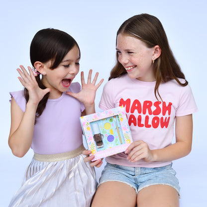 Two young girls holding a gift box with a blue background