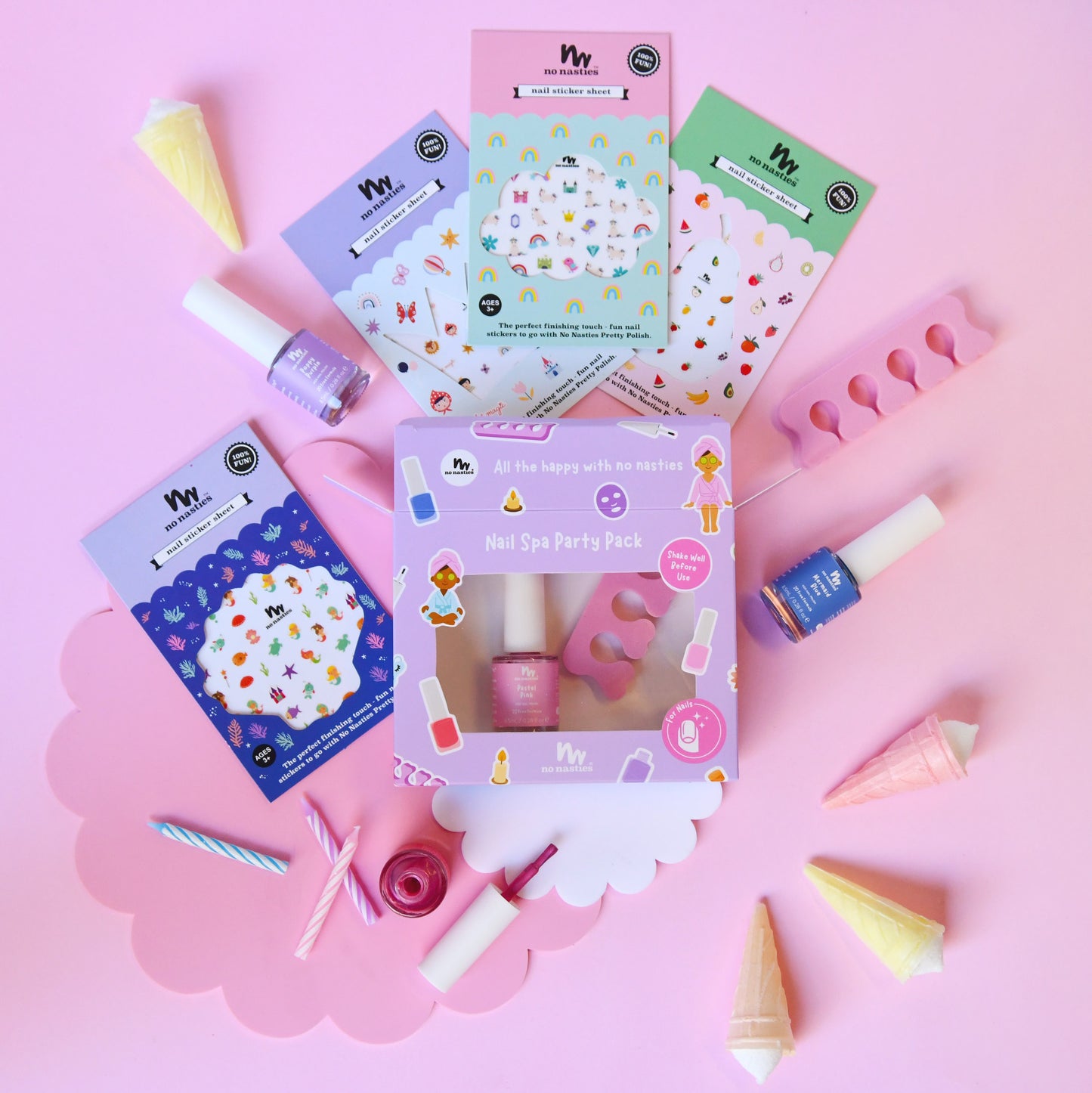 A flat-lay of a 'My' brand Non Spa Party Pack containing nail polish, nail stickers, and nail tools, arranged on a pink background with ice cream cone props.