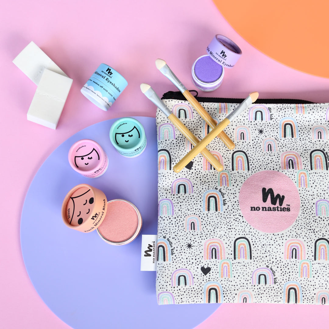 Makeup products and a pouch with 'no nasties' branding on a colorful background