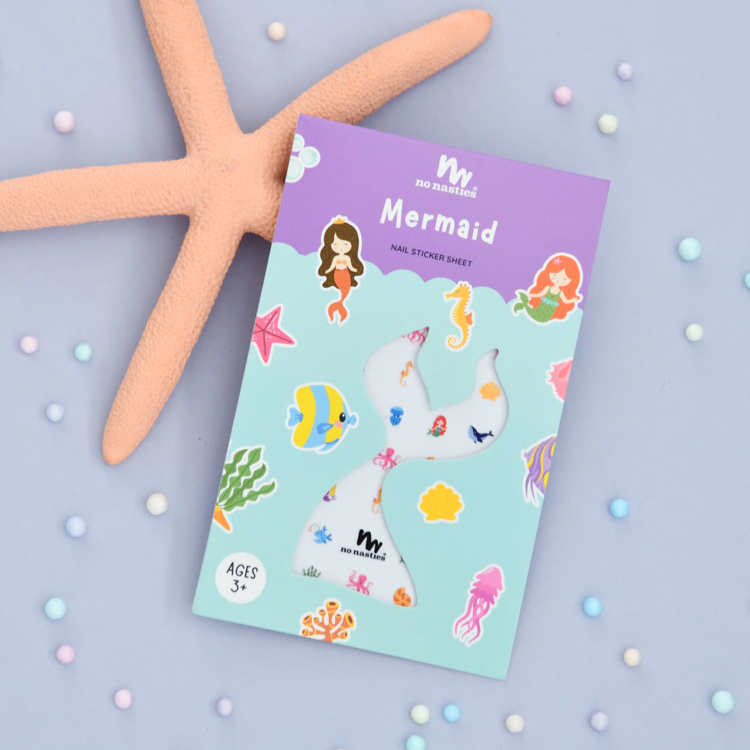 A package of Mermaid themed nail stickers with various sea creature designs placed on a surface with a starfish and small pearls around it.