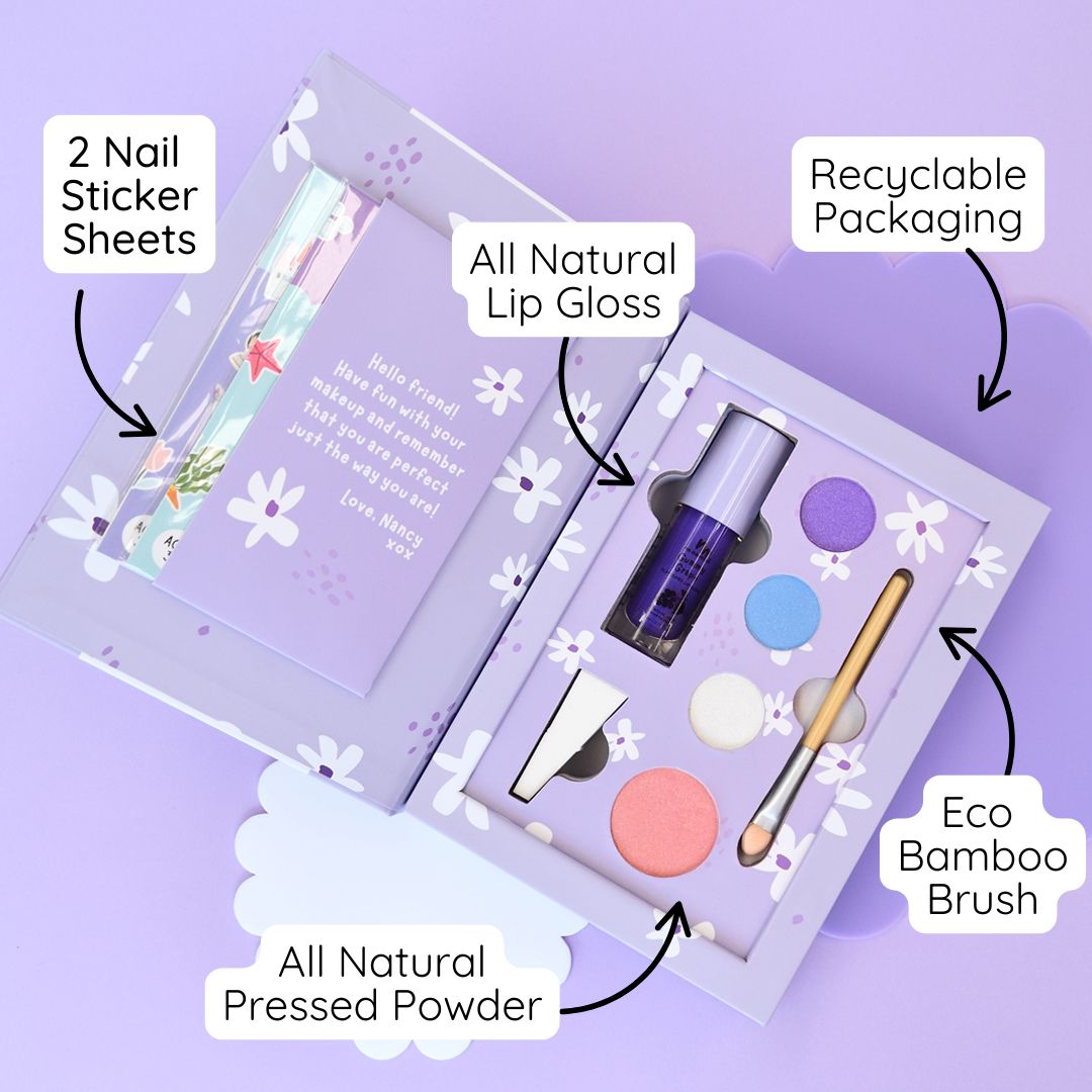 Makeup set with nail sticker sheets, lip gloss, pressed powder, and bamboo brush on a purple background
