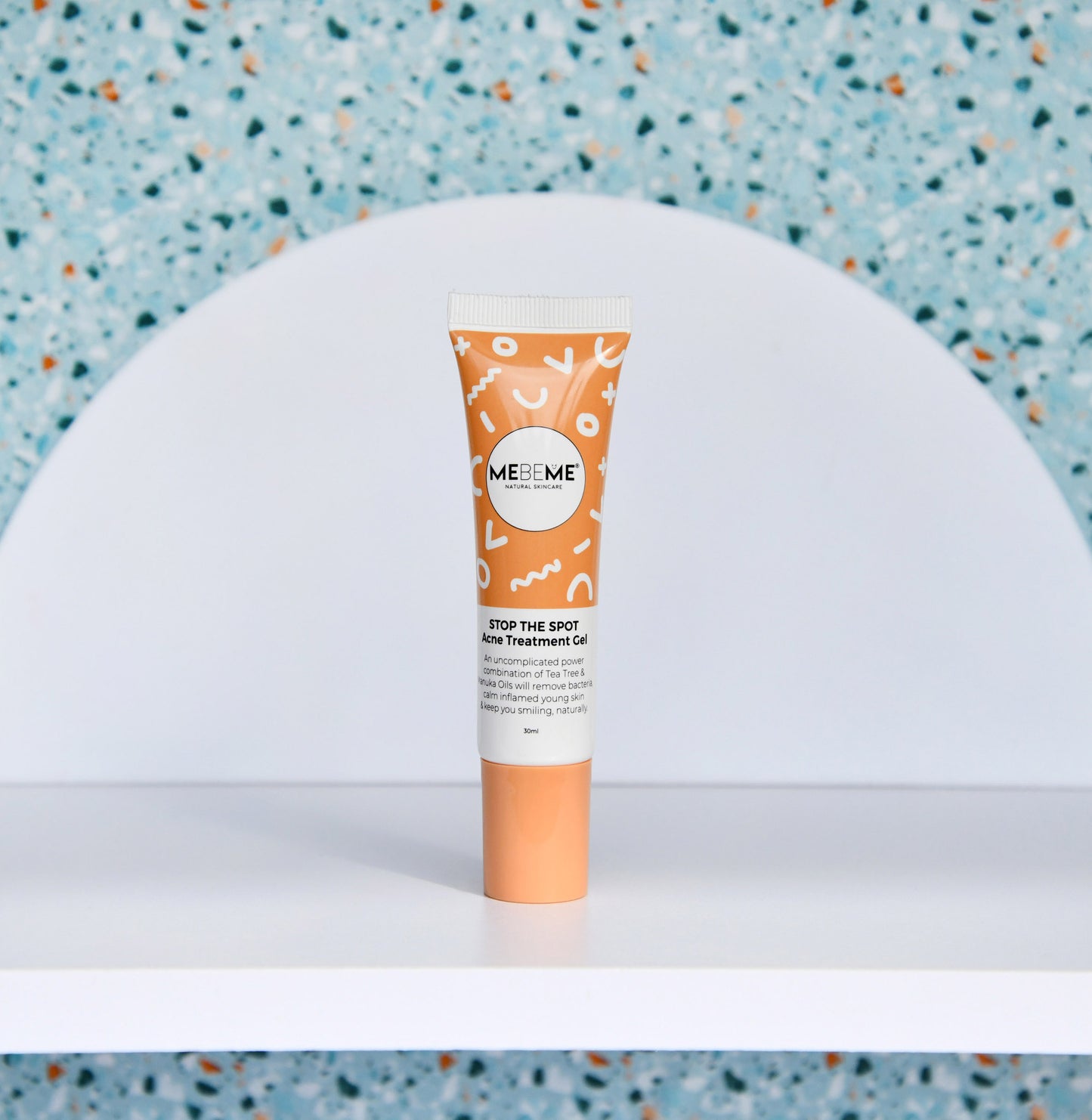 Tube of MeMe Skin treatment gel on a white surface with a blue textured background