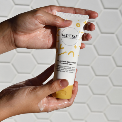 Hand holding a MEIMEI skincare product against a light geometric-patterned background