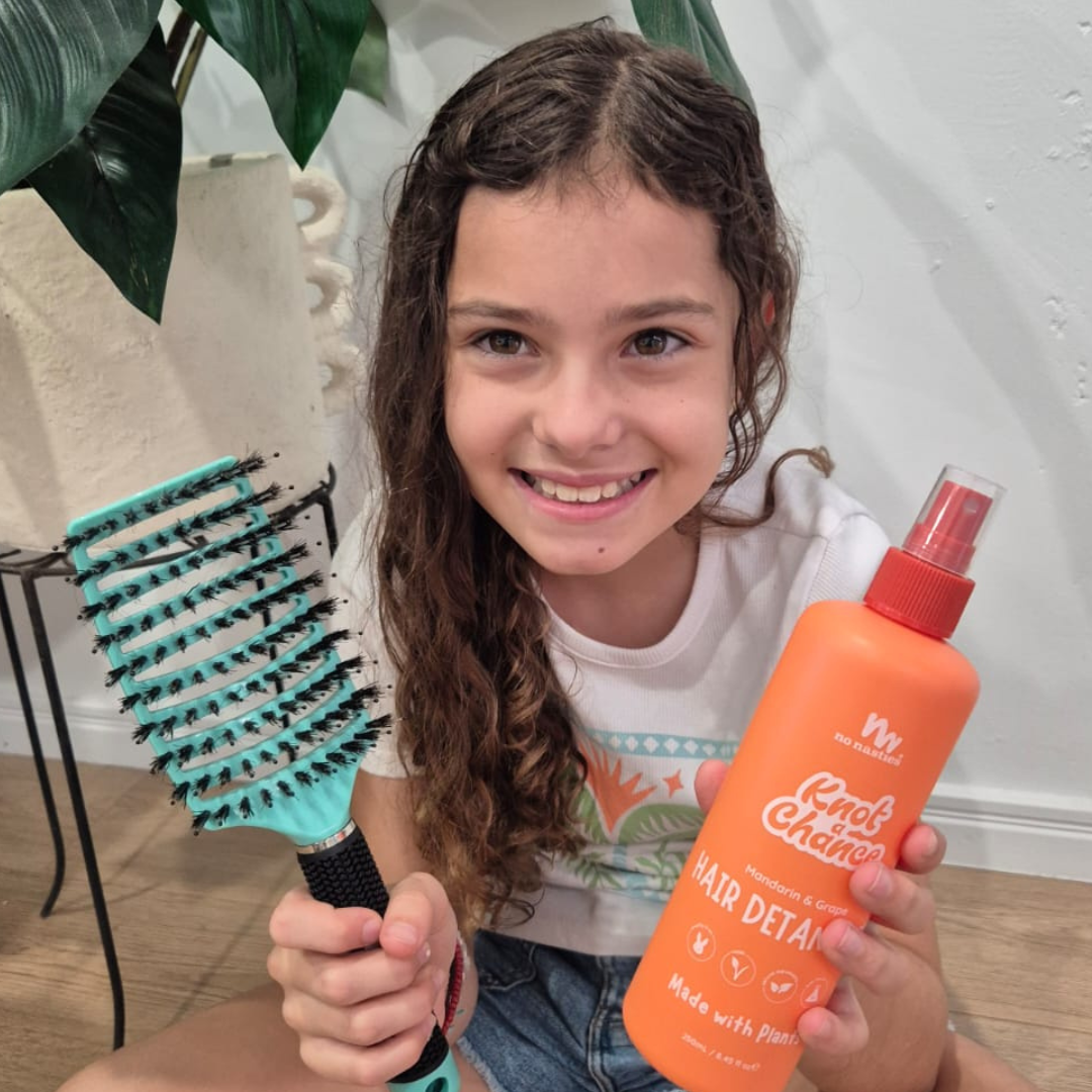 Child using natural hair detangler spray with detangling brush