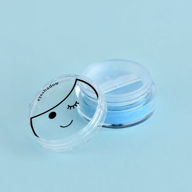 blue kids eyeshadow with little face on lid on pastel blue background