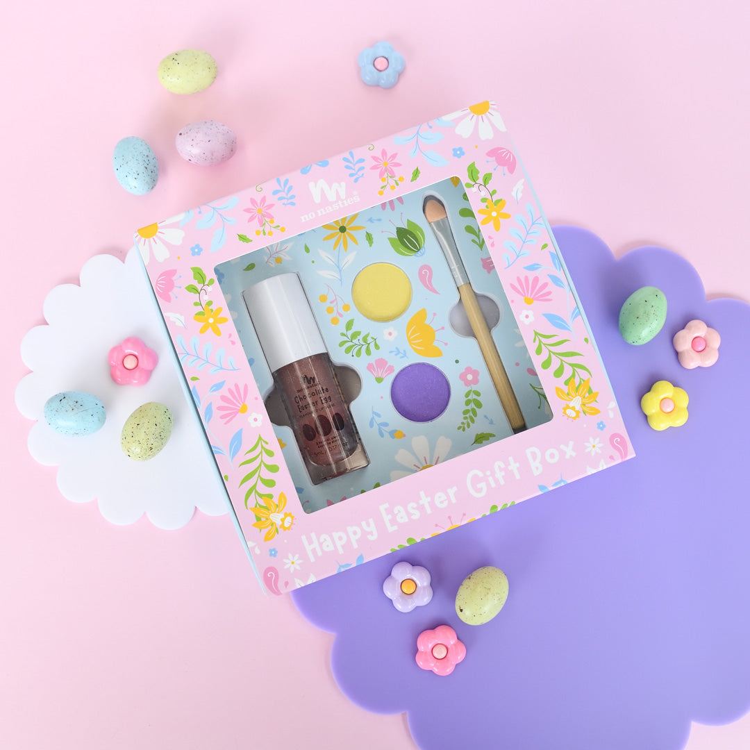 Easter-themed gift box with nail polish and brush on a pink background with Easter decorations.