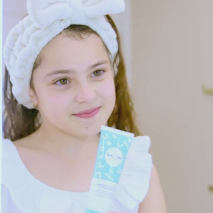 young-girl-applying-moisturiser-in-bathroom-mirror