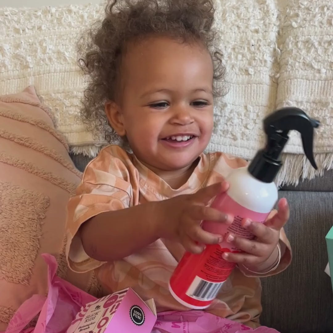 little girl shaking detangler bottle