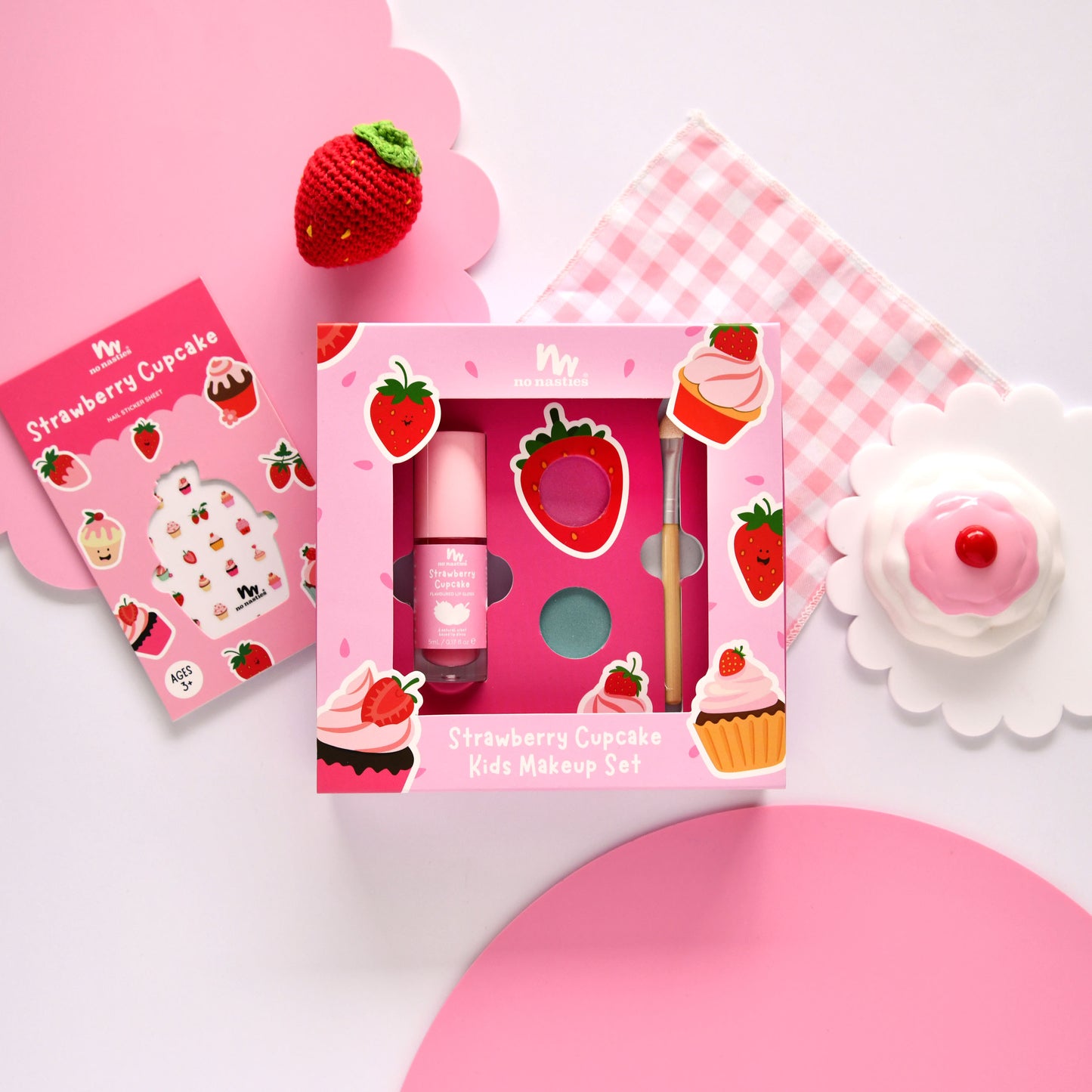 Strawberry-themed kids makeup set with pink packaging on a pink background