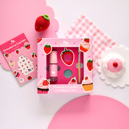 Strawberry-themed kids makeup set with pink packaging on a pink background