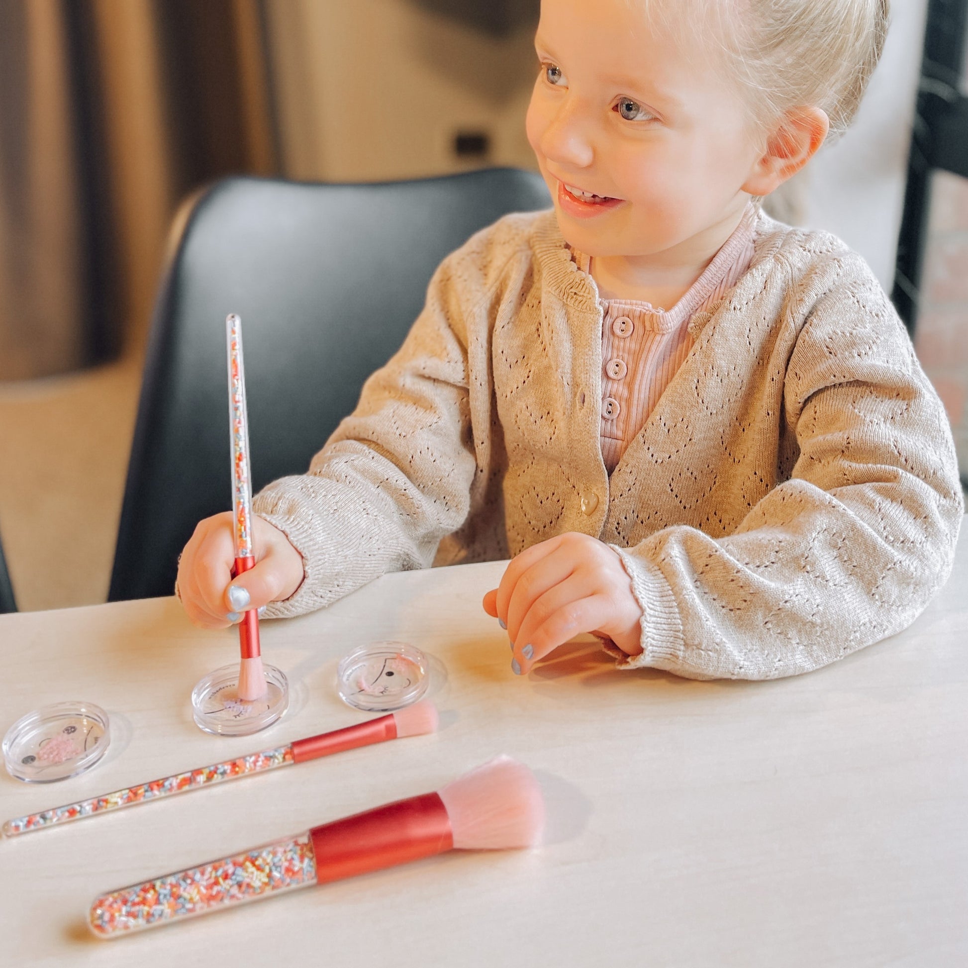 Little girl using Twinkle Sprinkle kids makeup brush set