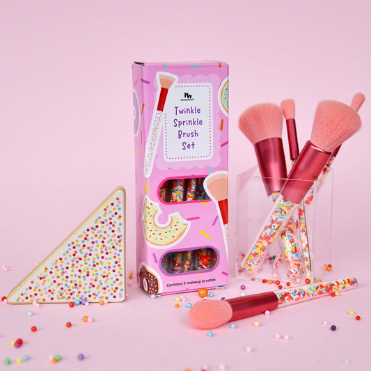 Makeup brush set with packaging on a pink background